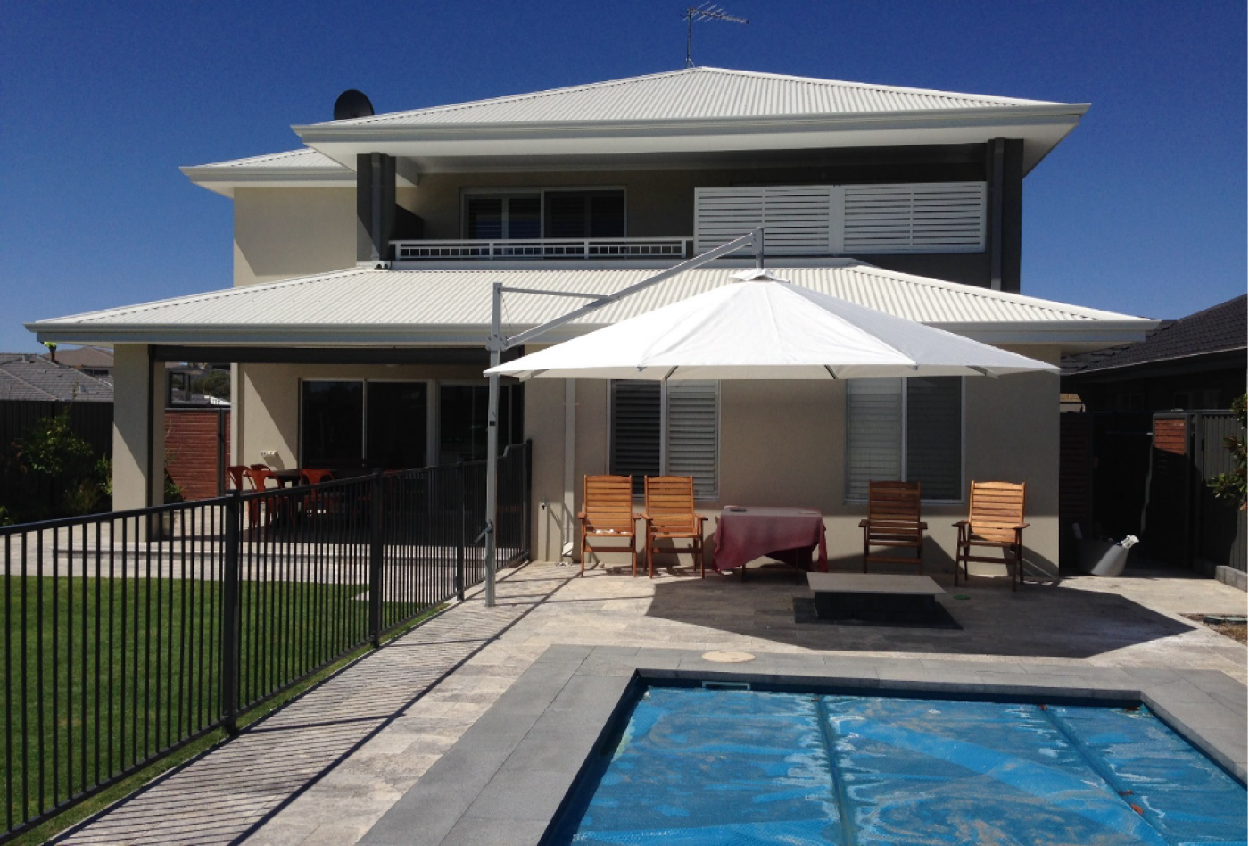 White Pacific Classic cantilever umbrella beside a swimming pool