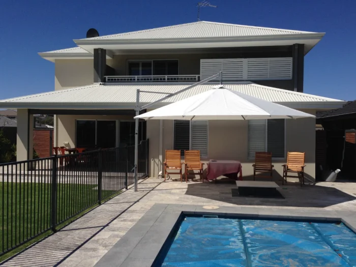 White Pacific Classic cantilever umbrella beside a swimming pool
